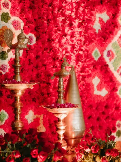 A close-up of the decor details from the Marathi wedding. Traditional brass diyas and a backdrop of vibrant red carnations highlight our commitment to weaving cultural symbols into the aesthetic, making the celebration feel both beautiful and meaningful.