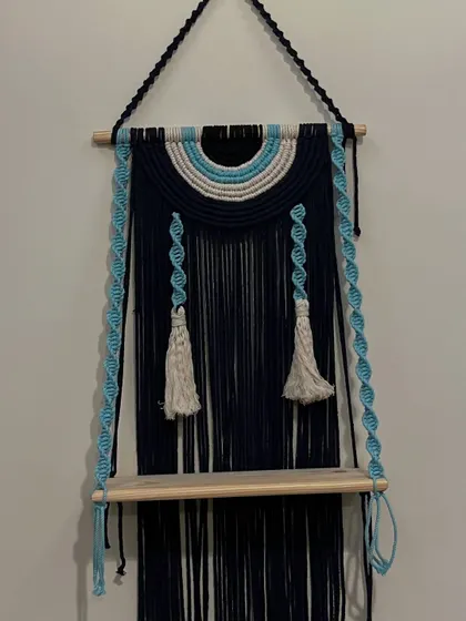 My evil eye wall shelf is a unique piece that combines style, function, and protection. The macrame backdrop features the evil eye colors, and the shelf is perfect for your favorite small items.