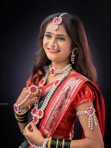 A classic three-quarter portrait of a woman showcasing her beautiful *halwyache dagine* and traditional saree for the Makarsankranti festival shoot.