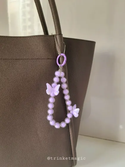 Another look at my purple butterfly beaded charm. The matching purple beads and butterflies create a cohesive and eye-catching accessory for any bag.