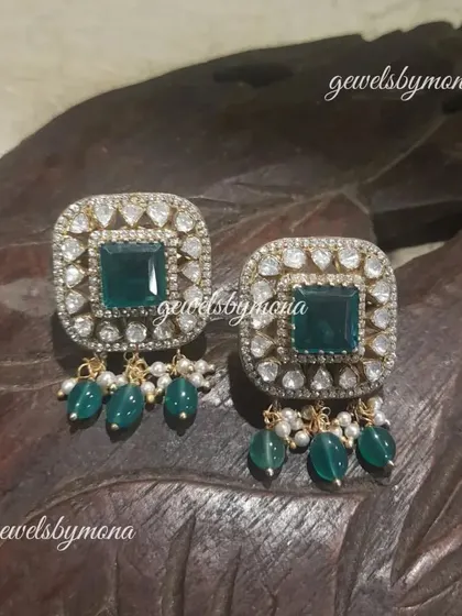 These square-shaped polki studs with green bead drops are a modern take on traditional design. They are perfect for adding a touch of sparkle and color to any outfit.