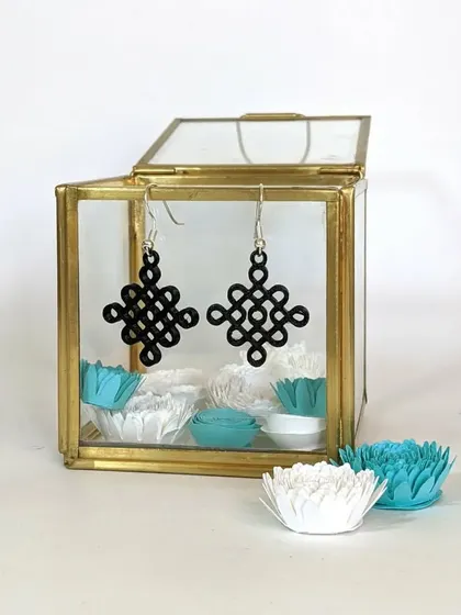 A pair of our 3D printed earrings, featuring an intricate knot design inspired by traditional Kolam patterns. We designed these in-house, showcasing the fine detail that 3D printing can achieve.