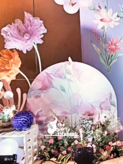 This corner vignette combines fairy cutouts, oversized organza flowers, and rustic crates to create a charming and whimsical photo opportunity.