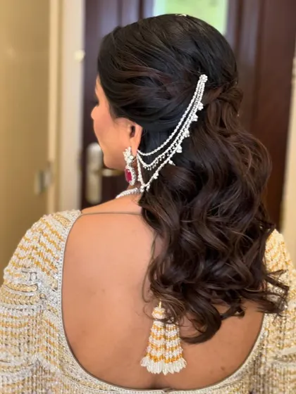 A side view of the elegant half-up style with a silver accessory.
