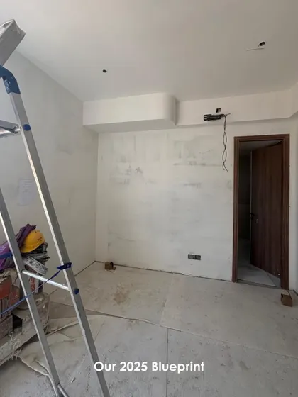 Every project begins as a blueprint on a raw site. This work-in-progress shot shows the initial stages of a project, with bare walls and a ladder, representing the blank canvas from which we begin to shape a new spatial experience.
