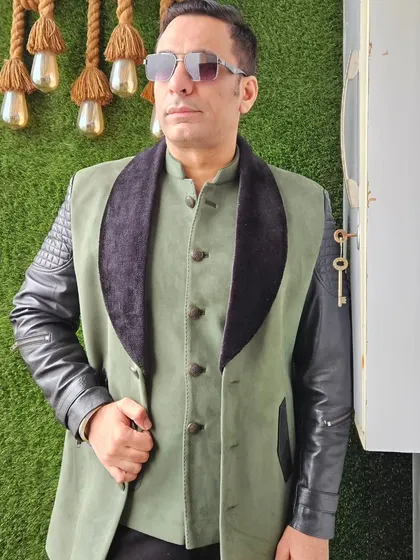 A very modern Indo-Western jacket in olive green with faux leather sleeves and a velvet lapel. This is for the man who is not afraid to experiment with his style.