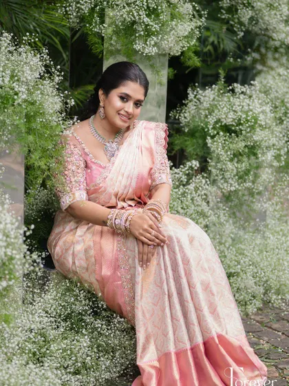 A beautiful portrait of the bride in her engagement outfit. The blush pink blouse is covered in 3D floral appliqué and beadwork, creating a romantic and ethereal feel.
