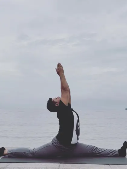 Hanumanasana, the full split, practiced by the sea. This pose embodies devotion and a leap of faith.