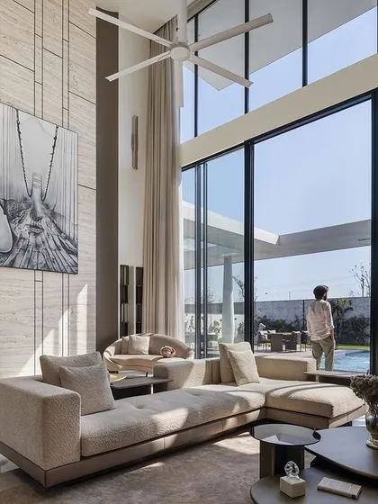 This double-height living room is designed to inspire. The floor-to-ceiling windows flood the space with natural light and offer panoramic views of the pool, while the monumental artwork and contemporary furniture create an atmosphere of pure bliss.
