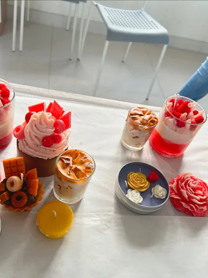 A beautiful display of various candle types, from dessert jars to floral designs.
