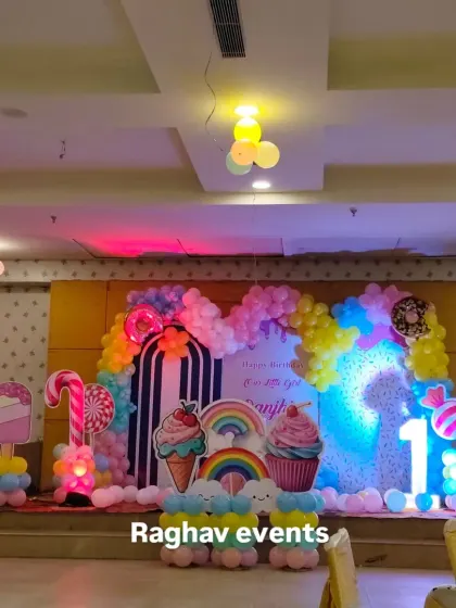 A wide shot of the candyland themed birthday party, showing the entire stage setup in the venue.