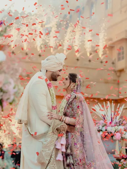 A moment of pure joy as the couple is showered with petals. The grandeur of the Suryagarh palace provides a timeless backdrop to this vibrant and emotional wedding ceremony.