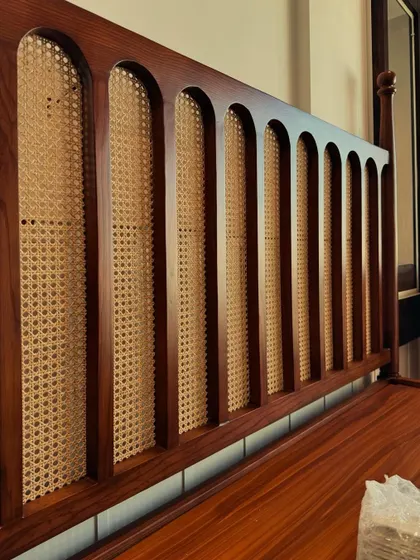 Retro called. It wants its charm back, but we said no, it’s staying here. A close-up of the arched details on a cane and wood headboard.