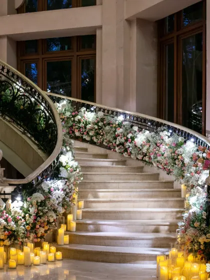 The grand staircase at The Leela Palace Bengaluru, adorned with cascading pastel florals and hundreds of candles. This breathtaking installation was part of the 'Whispers of Spring' theme, creating a truly magical entrance.