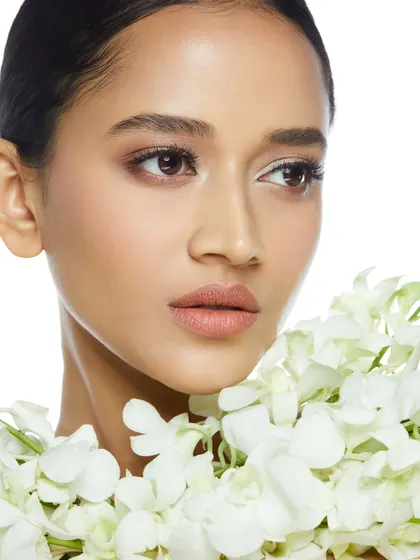 A fresh and clean bridal look with soft, minimal makeup and a beautiful garland of white flowers.