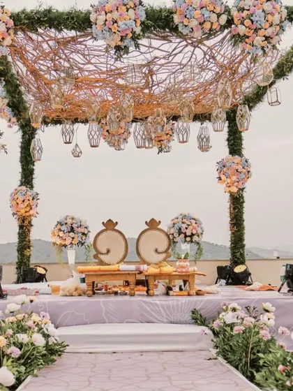 A unique mandap design featuring a canopy of intertwined branches and pastel floral bunches. This rustic-chic style is perfect for a whimsical, enchanted forest theme.