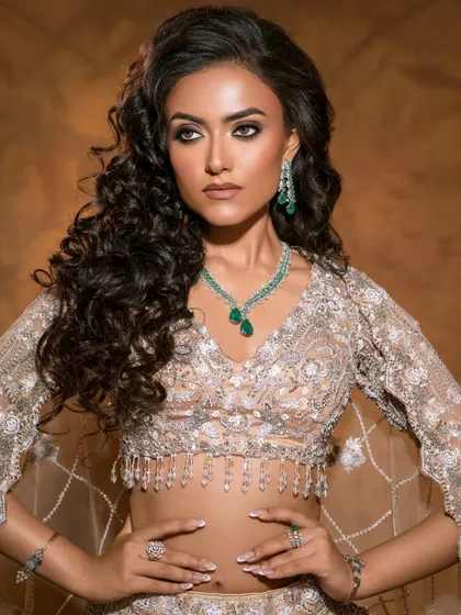 A mid-shot that captures the soft, romantic feel of the look, with voluminous curls and classic smokey eyes complementing the delicate outfit.