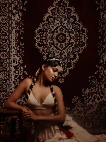 Another shot from the 'Lila' series, where the model is seated. The composition uses the ornate carpet as a backdrop to frame the subject, highlighting the traditional-meets-boho styling.