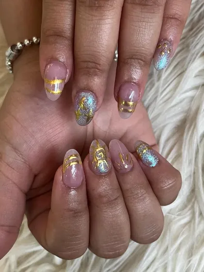 A unique design with a sheer pink base, gold line work, and a beautiful blue and gold glitter accent.