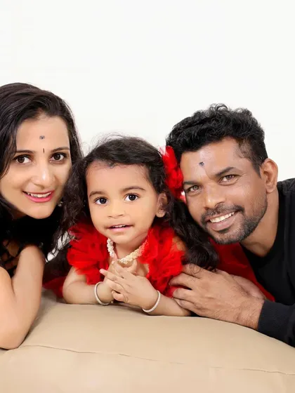 A candid and happy family portrait. The genuine smiles and relaxed poses create a natural and heartwarming image that reflects the family's love.