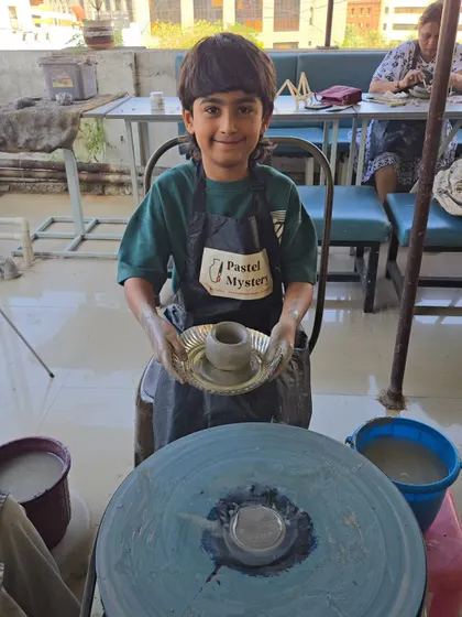 Look at that proud face. This young artist has just finished shaping his first pot on the wheel. My goal is for every child to leave with a sense of accomplishment and a masterpiece they're excited to show off.