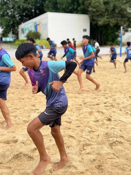 The U15 team performing running drills on the sand to build cardiovascular endurance and leg strength.