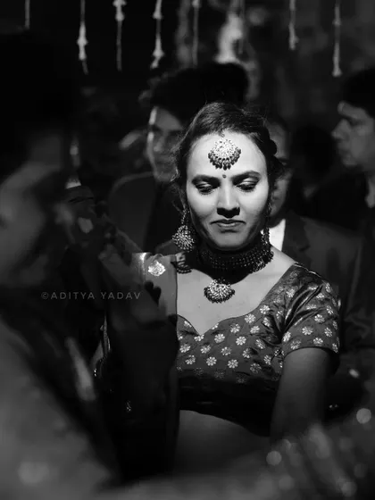 A candid black and white photo of a guest dancing during the sangeet or reception. The focus is on her expressive movement, capturing the joyful and energetic atmosphere of the celebration.