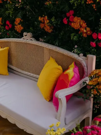 The main seating for the bride during the Mehendi ceremony, surrounded by colorful flowers.