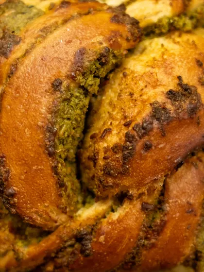 A close-up texture shot of our Chilli Cheese Toast Babka, showing the beautiful swirls of pesto and golden-brown crust.