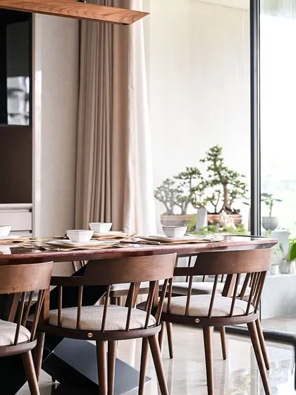 The careful placement of furniture ensures that every seat in the dining area has a beautiful view, whether of the interior spaces or the green deck outside.