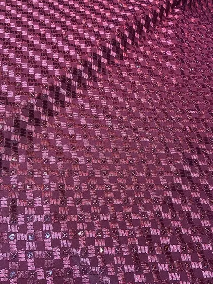 A unique maroon Chikankari fabric with a checkerboard-style embroidery pattern and sequins. This textile can be used to create a truly distinctive custom kurta.
