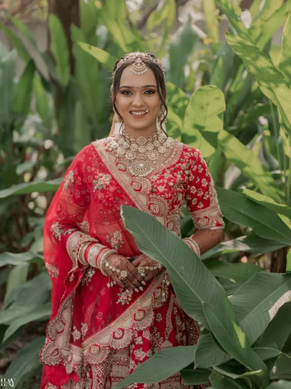 A beautiful close-up portrait of the bride, her smile framed by tropical leaves.