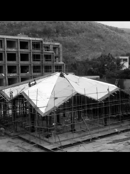 An archival photo of the Lotus Cafe roof being clad. This image captures the moment where the structural frame begins to take its final shape.