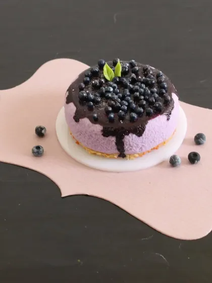 A close-up of the miniature blueberry cheesecake, showing the glossy topping and delicate details.
