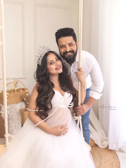 A joyful couple's portrait on the studio swing. The addition of the crown to the boho-chic setup creates a unique and playful "queen of the castle" vibe.