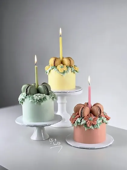 These pretty pastel mini-cakes are topped with macarons and delicate buttercream flowers. A beautiful fusion of two popular desserts.