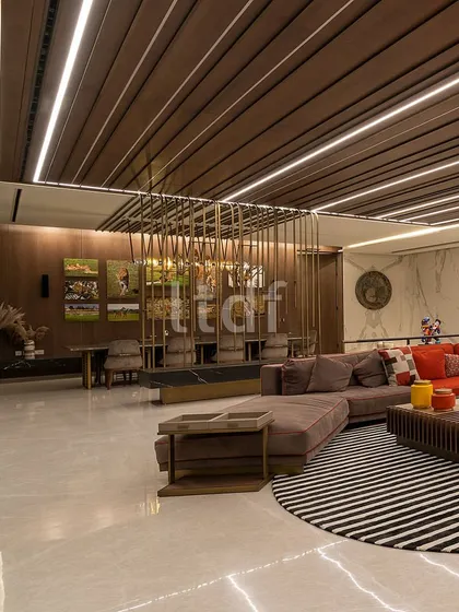 This capacious living room exudes modern luxury through its vast dimensions and minimalist aesthetic. We used an earthy color palette and integrated diverse materials like wood, marble, and metal to create an atmosphere of refined opulence that feels both uncluttered and inviting.