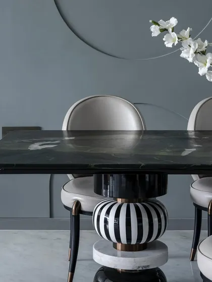 A close-up of the sculptural dining table base in 'The House of Arcs', showcasing the mix of materials and patterns.
