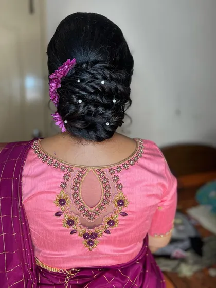 A soft and romantic messy bun adorned with flowers. This versatile hairstyle works beautifully for sangeet, reception, or even a modern pre-wedding look.