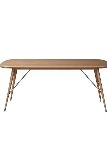 A studio shot of the Volta Dining Table in solid walnut. The design features a leather-trimmed tabletop and elegant tapered legs with matte brass caps, showcasing the collection's signature blend of rebellion and sophistication.