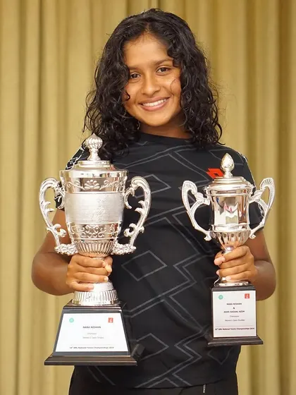 A double victory smile. One of our star players proudly holds her trophies for winning both the Women's Open Singles and Doubles at the Bank of Maldives National Tennis Championship 2024.