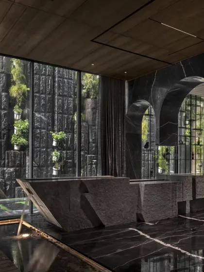 This bar counter at the Green Court Villa is sculpted from split stone, interacting with a water body below. It's a prime example of how I use raw materials to create functional art that engages the senses.