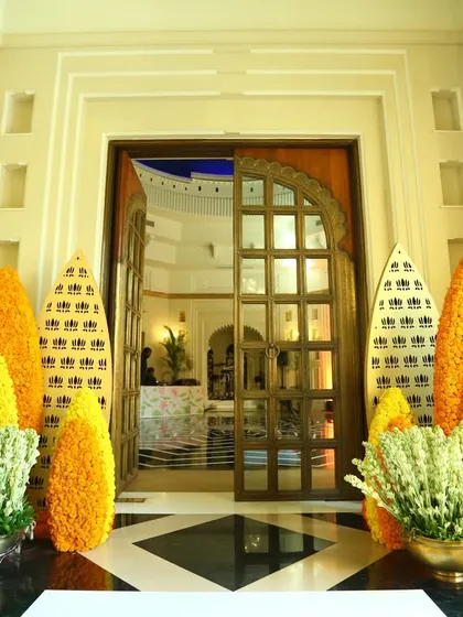 A traditional yet elegant entrance decor for a Sangeet in Rajasthan, using marigolds and carved wooden panels.