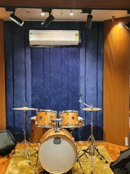 The drum corner in our live room, set up and ready to go. The checkered acoustic wall isn't just for looks; it helps control sound reflections, ensuring a tight and punchy drum recording.