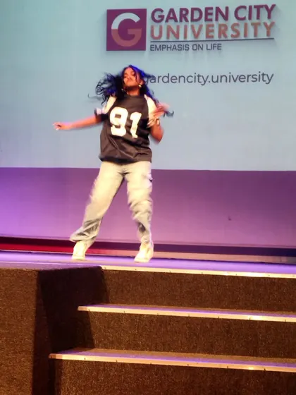 A dynamic action shot of a performer during the judging of the solo dance competition at Garden City University.