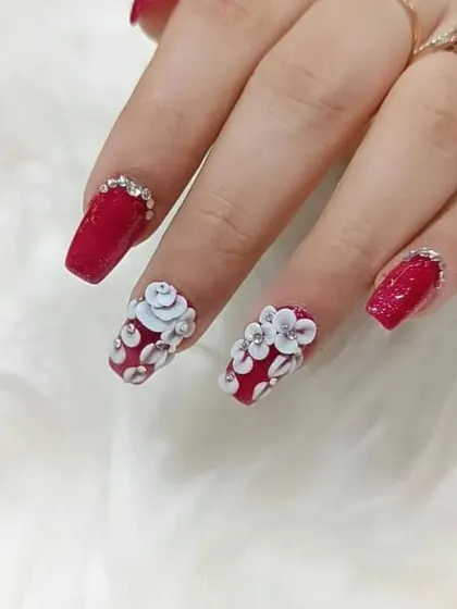 A full view of the glamorous red and white 3D floral set. The combination of glitter, sculpted art, and rhinestones creates a luxurious and eye-catching manicure.