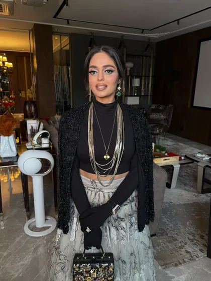 The full outfit, showing how the modern, accessory-heavy braid complements the chic and layered ensemble.
