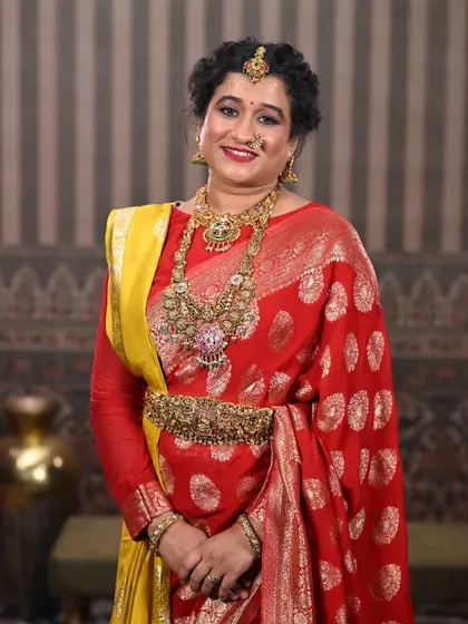 A close-up portrait that highlights the intricate details of the layered necklaces and the matching waist belt.