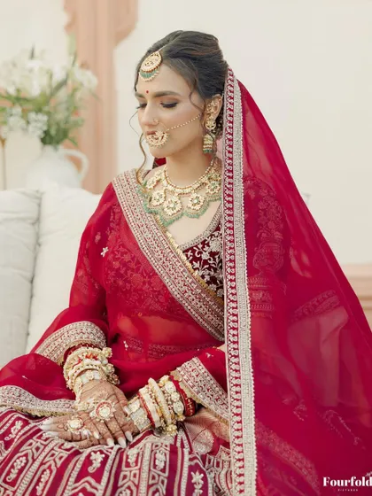 A serene portrait of Janvi. Her soft makeup, with a focus on a flawless base and defined eyes, perfectly complemented her traditional red bridal lehenga.