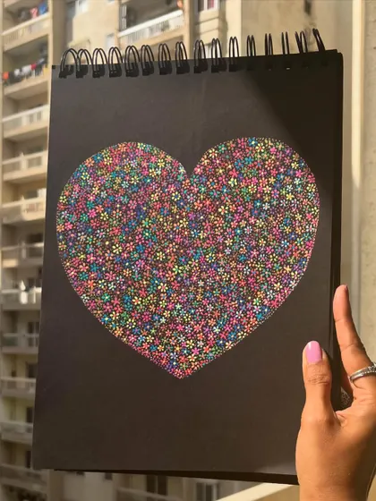The floral heart held up against a bright background.